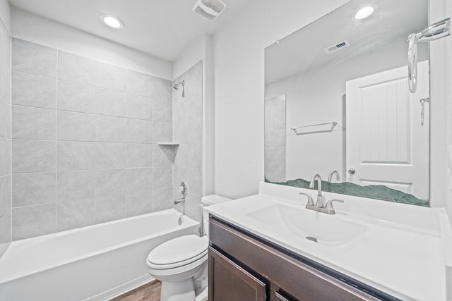 full bathroom featuring hardwood / wood-style floors, toilet, vanity, and tiled shower / bath