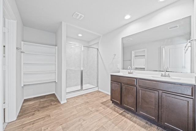 bathroom featuring a shower with door, hardwood / wood-style flooring, and vanity