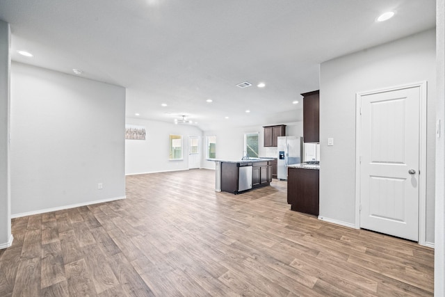 kitchen featuring hardwood / wood-style floors, dark brown cabinetry, a center island, and stainless steel appliances