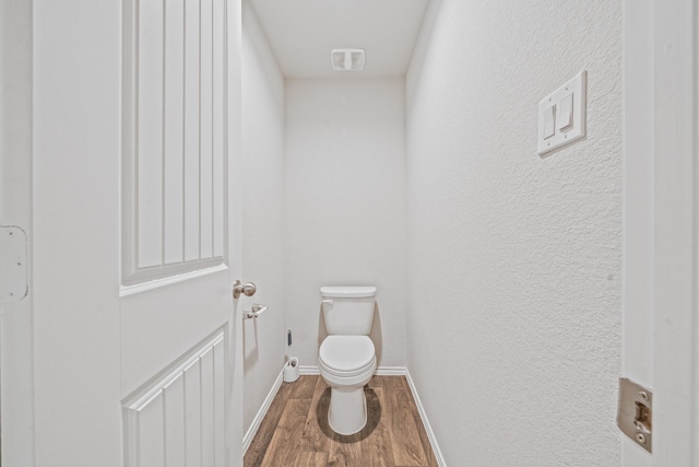 bathroom with toilet and hardwood / wood-style floors