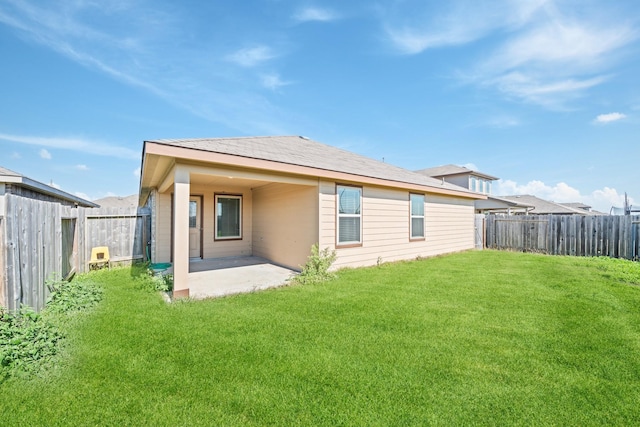 rear view of house featuring a yard and a patio