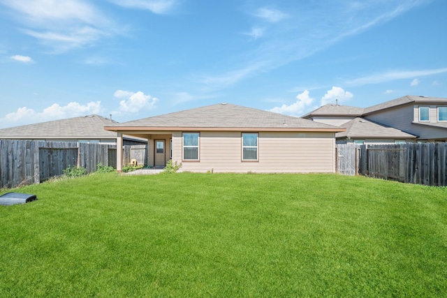 rear view of property with a yard