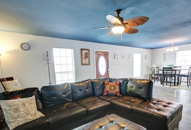 living room featuring hardwood / wood-style floors and ceiling fan with notable chandelier