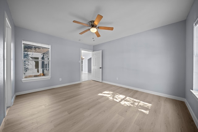 empty room with ceiling fan and light hardwood / wood-style flooring