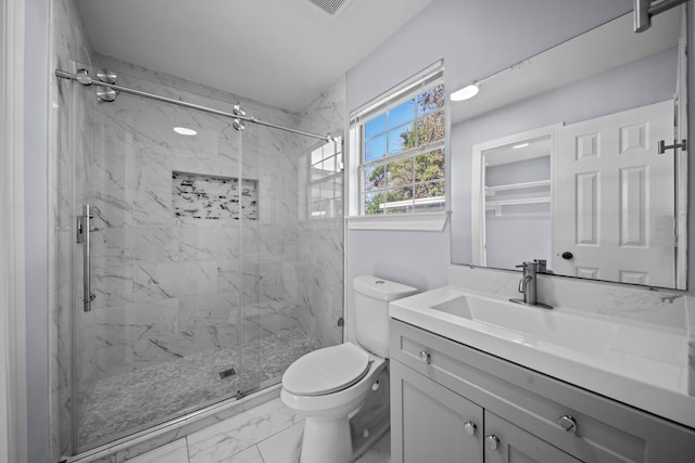 bathroom featuring a shower with shower door, toilet, and vanity