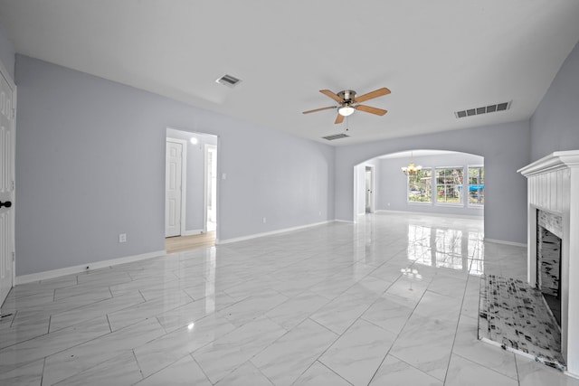 unfurnished living room featuring ceiling fan with notable chandelier