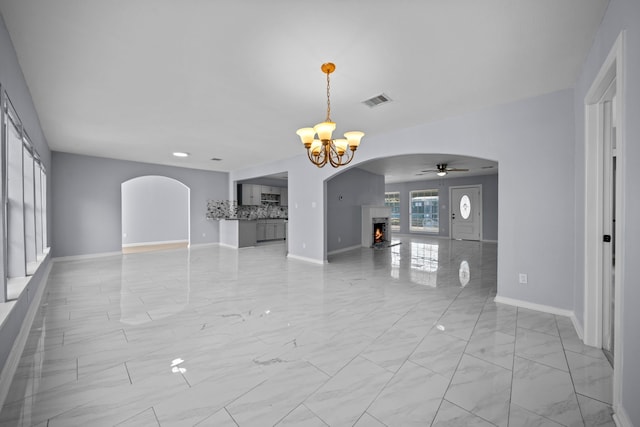 interior space with ceiling fan with notable chandelier