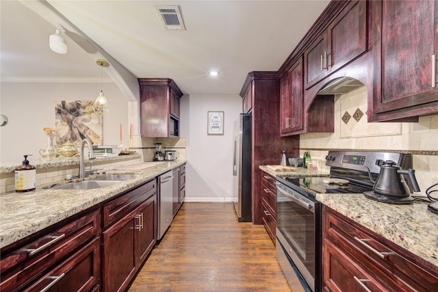 kitchen with decorative backsplash, sink, hanging light fixtures, light stone countertops, and stainless steel appliances