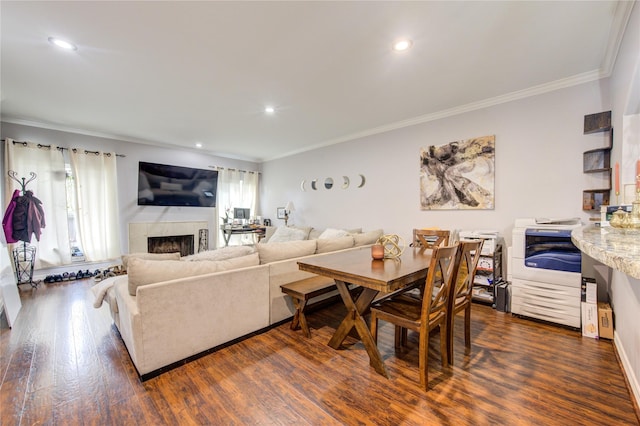 living room featuring dark wood-type flooring, a high end fireplace, a wealth of natural light, and crown molding