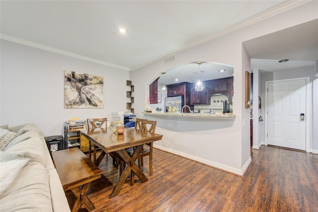 dining room with ornamental molding, dark hardwood / wood-style floors, and sink