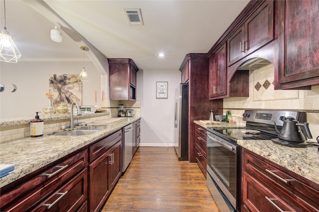 kitchen featuring appliances with stainless steel finishes, sink, light stone counters, and decorative light fixtures