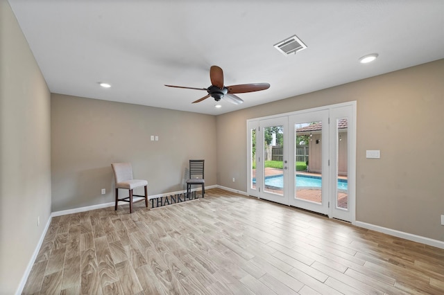 unfurnished room with ceiling fan, light hardwood / wood-style floors, and french doors