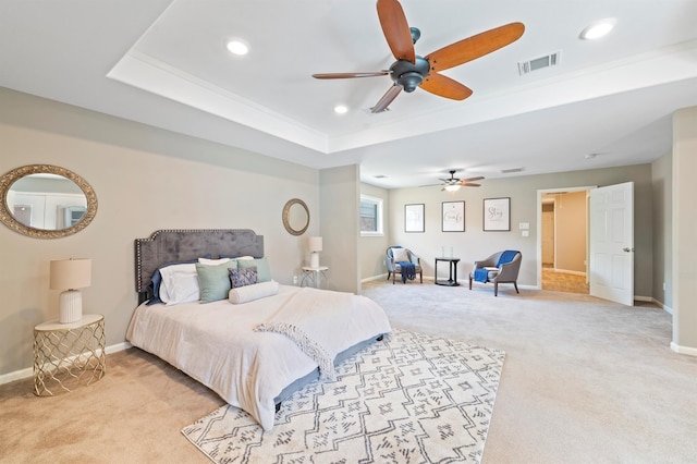 bedroom with ceiling fan, a tray ceiling, and light carpet