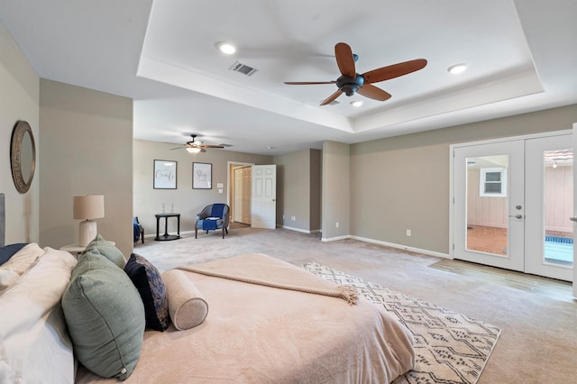 bedroom with ceiling fan, access to exterior, a tray ceiling, and french doors