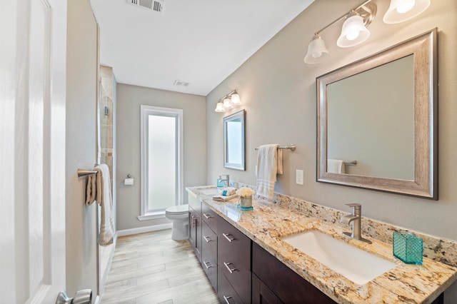 bathroom with toilet, vanity, and hardwood / wood-style floors