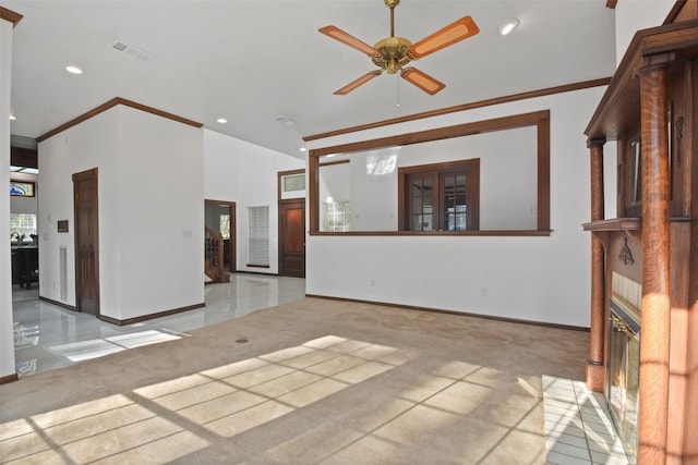 unfurnished living room with ceiling fan, a brick fireplace, and ornamental molding