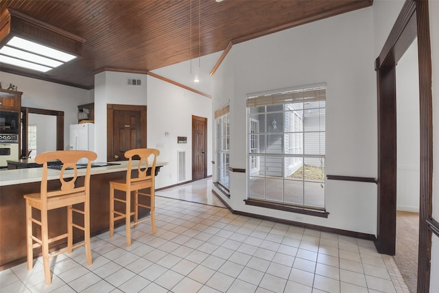 tiled dining room featuring crown molding and wood ceiling