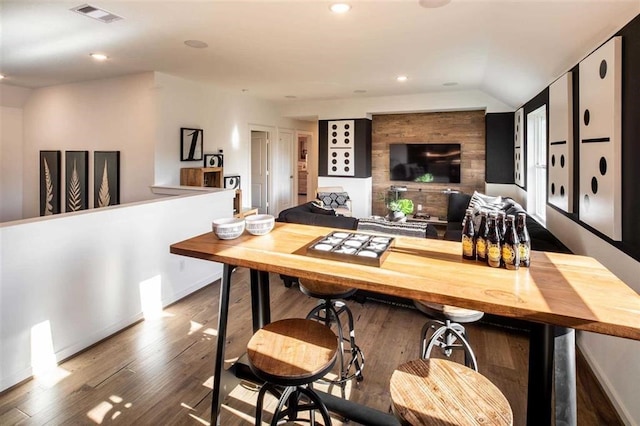 dining room featuring dark wood-type flooring and lofted ceiling