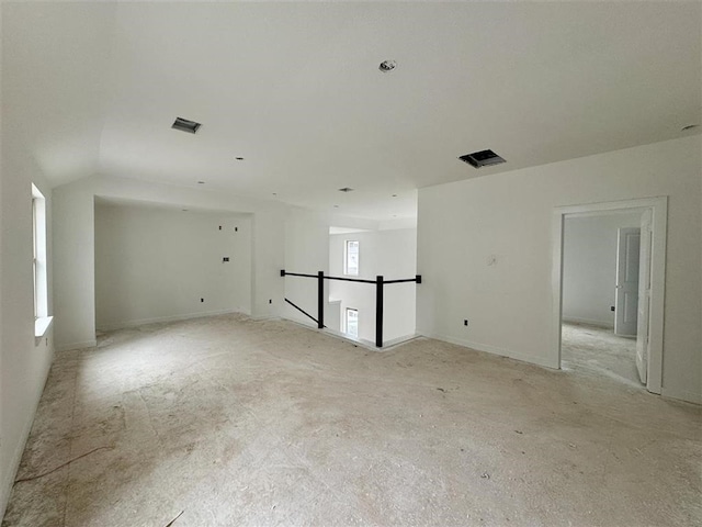 unfurnished room with lofted ceiling