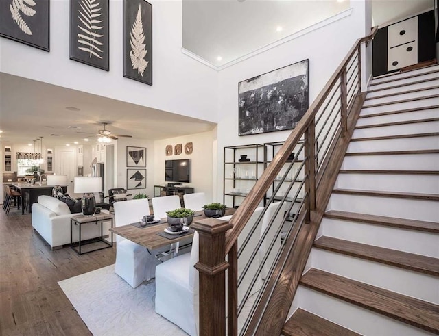 stairs with ceiling fan and hardwood / wood-style floors