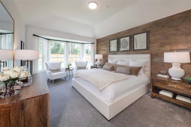 carpeted bedroom featuring wood walls and lofted ceiling