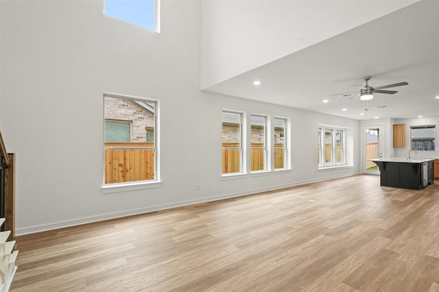 7462 Cattail Falls Ln, Porter, TX 77365 - unfurnished living room featuring light wood-style flooring, ceiling fan, recessed lighting, and baseboards