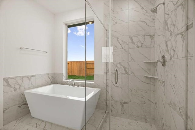 bathroom with tile walls and separate shower and tub