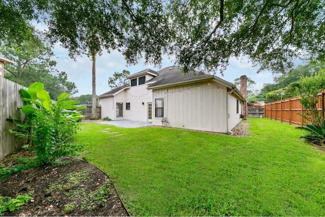 back of property with a yard and a patio area