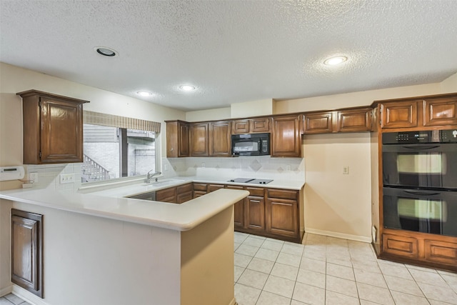 kitchen with sink, a textured ceiling, black appliances, and kitchen peninsula