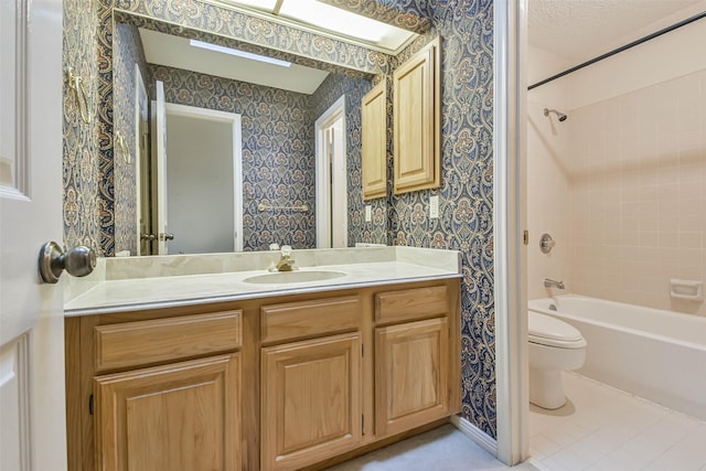 full bathroom with tile patterned floors, tiled shower / bath combo, vanity, and toilet