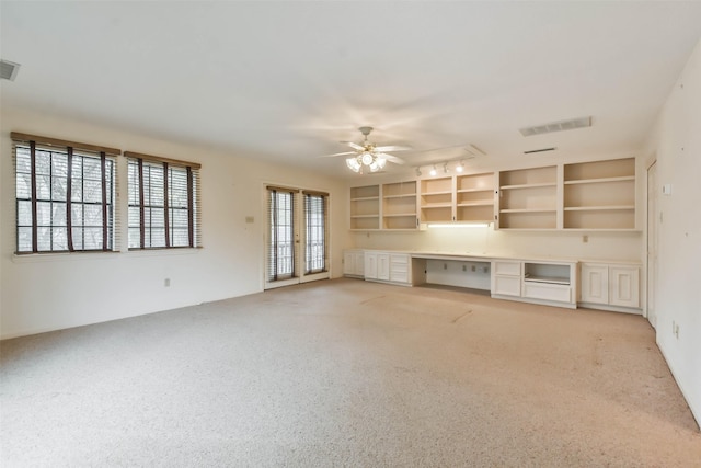 unfurnished living room with ceiling fan, light colored carpet, french doors, and rail lighting