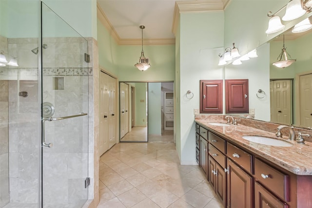 bathroom with a shower with shower door, vanity, tile patterned floors, and crown molding