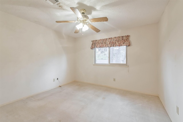 carpeted spare room featuring ceiling fan and a textured ceiling