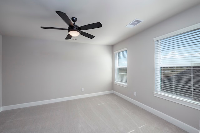 spare room with ceiling fan and light colored carpet