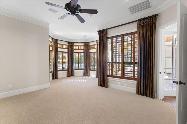 spare room with light carpet, ceiling fan, a wealth of natural light, and ornamental molding