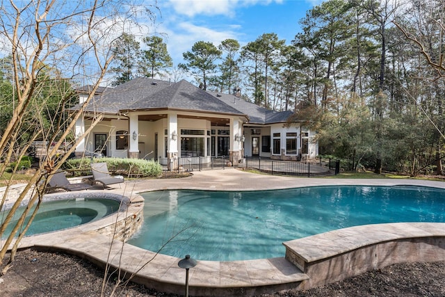 outdoor pool with an in ground hot tub, a patio, and fence