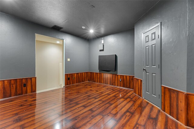 unfurnished room featuring a textured ceiling and hardwood / wood-style floors