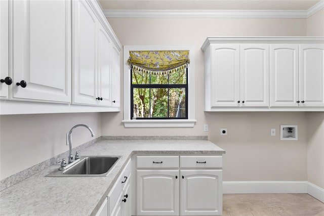 clothes washing area featuring hookup for an electric dryer, washer hookup, cabinets, crown molding, and sink