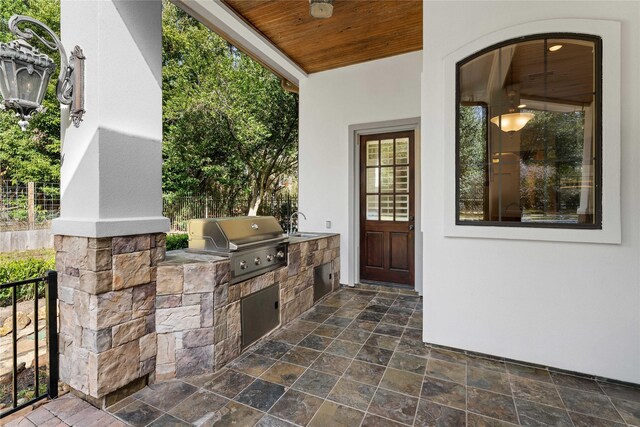 view of patio with ceiling fan, a grill, and an outdoor kitchen