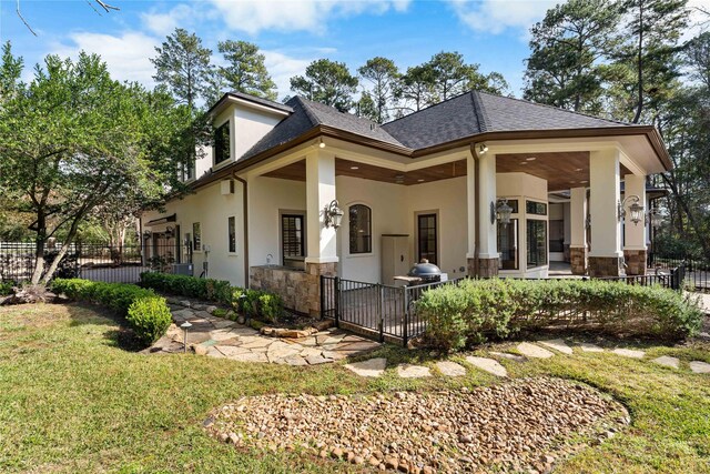 back of house with ceiling fan and a yard