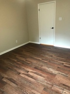 unfurnished room with dark wood-type flooring