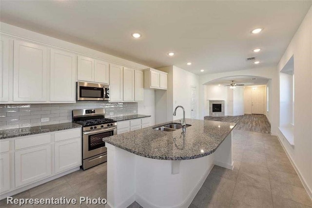 kitchen featuring ceiling fan, sink, white cabinets, and stainless steel appliances