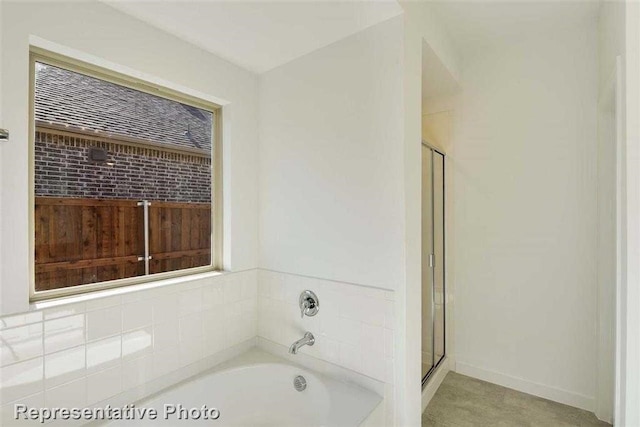 bathroom featuring plenty of natural light and shower with separate bathtub