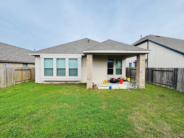 rear view of property featuring a lawn and a patio area