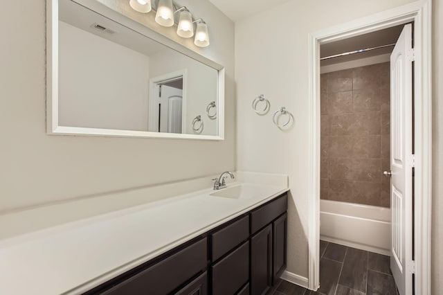 bathroom with tiled shower / bath combo and vanity