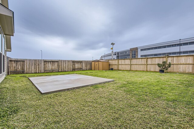 view of yard featuring a storage unit and a patio