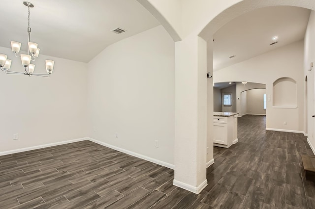 7535 Cypress Pin Oak Dr, Cypress, TX 77433 - empty room featuring lofted ceiling, dark wood-style flooring, visible vents, arched walkways, and an inviting chandelier