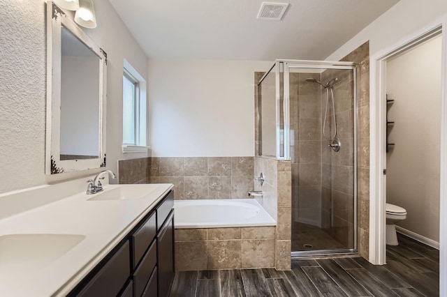 full bathroom with toilet, vanity, and shower with separate bathtub