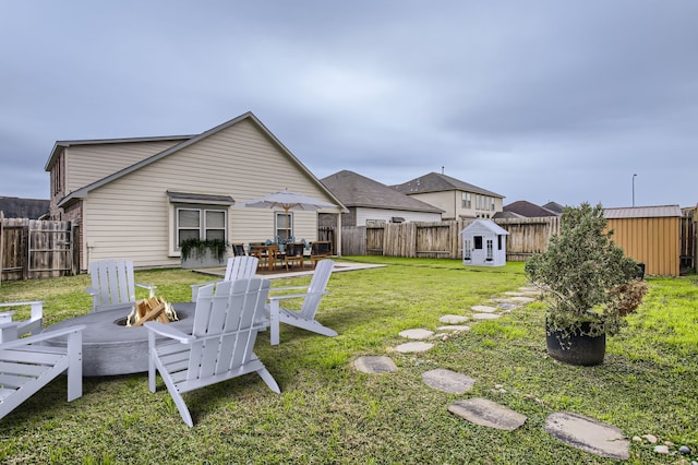 7535 Cypress Pin Oak Dr, Cypress, TX 77433 - view of yard featuring a patio, an outdoor fire pit, a fenced backyard, a storage unit, and an outbuilding
