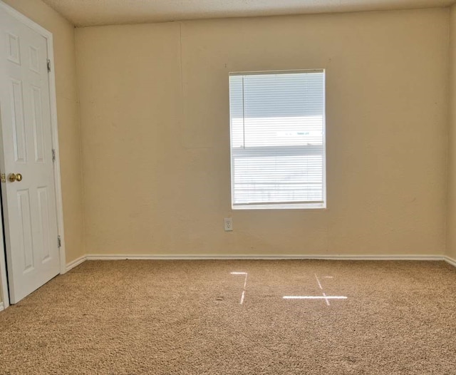 empty room with carpet and baseboards